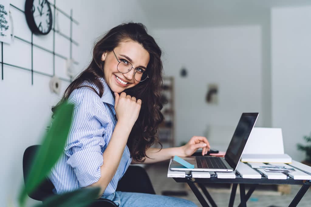 mulher em seu escritrio interagindo com seu pblico nas redes sociais pelo seu notebook